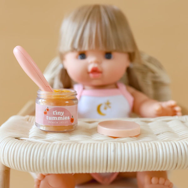 Tiny tummies doll food jar peach jelly sitting on tiny harlow rattan doll's highchair with blonde doll sitting in seat