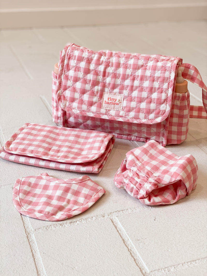 Tiny Harlow doll's nappy bag set in pink gingham featuring bag, change mat, bib and nappy for dolls